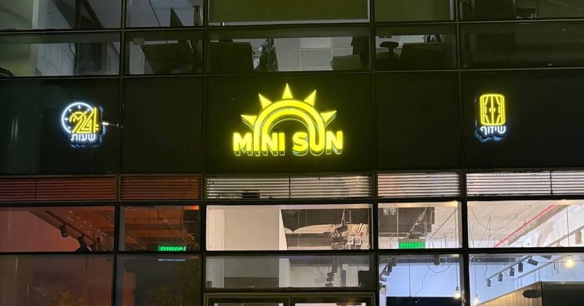 חזית הסניף בלילה עם שלט MINI SUN מואר — מיני סאן חולון