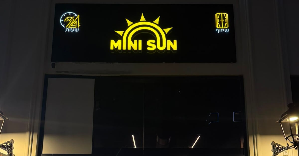 חזית הסניף בערב עם שלט MINI SUN מואר — מיני סאן נתניה