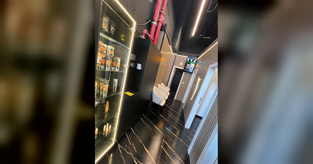 מסדרון עם ויטרינת מוצרי שיזוף מוארת — מיני סאן מודיעין