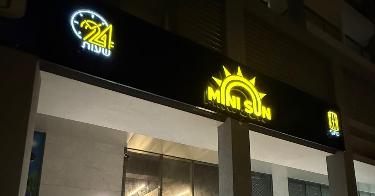 חזית הסניף בלילה עם שלט MINI SUN מואר — מיני סאן קריית גת