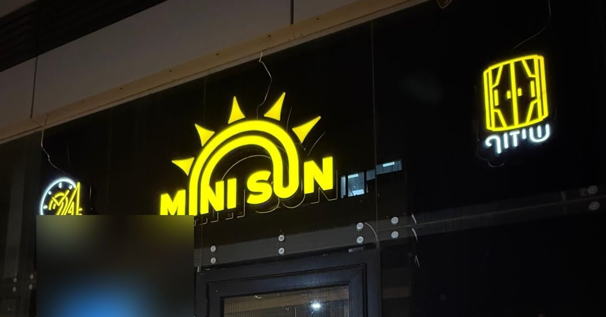 חזית הסניף בלילה עם שלט MINI SUN מואר — מיני סאן פתח תקווה