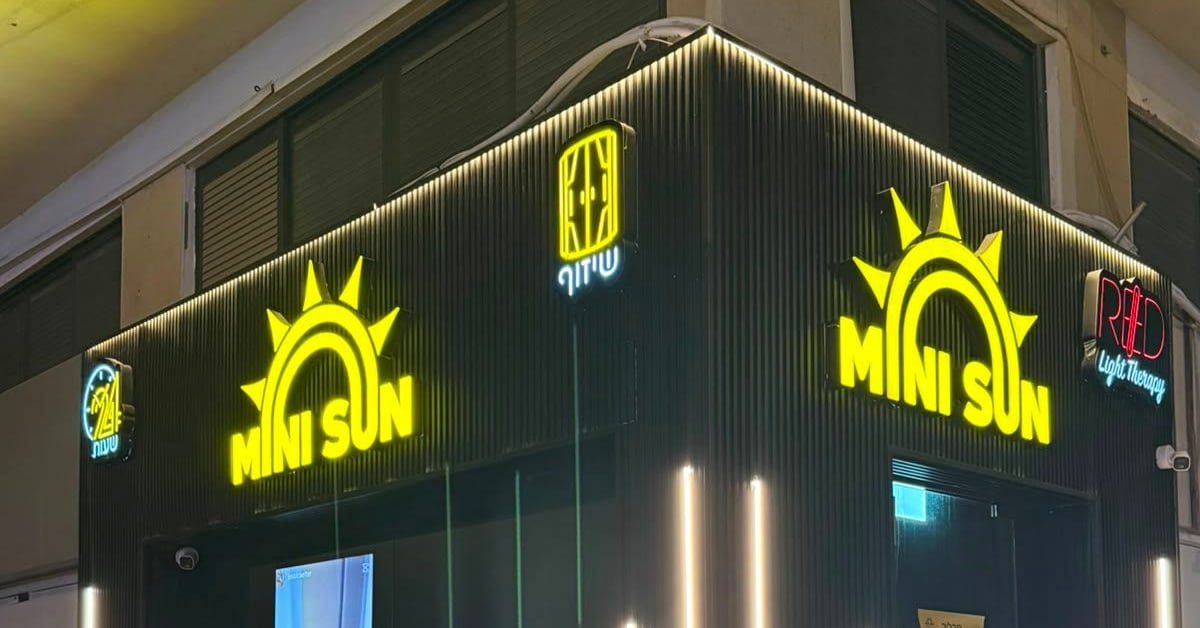 חזית הסניף בערב עם שלטי MINI SUN מוארים — מיני סאן חדרה