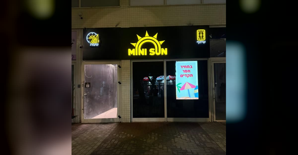 חזית הסניף ברחוב ויצמן בלילה עם שלט MINI SUN מואר — מיני סאן כפר סבא