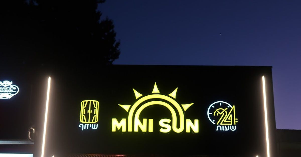 חזית הסניף בלילה עם שלט MINI SUN ותאורת לד — מיני סאן יבנה