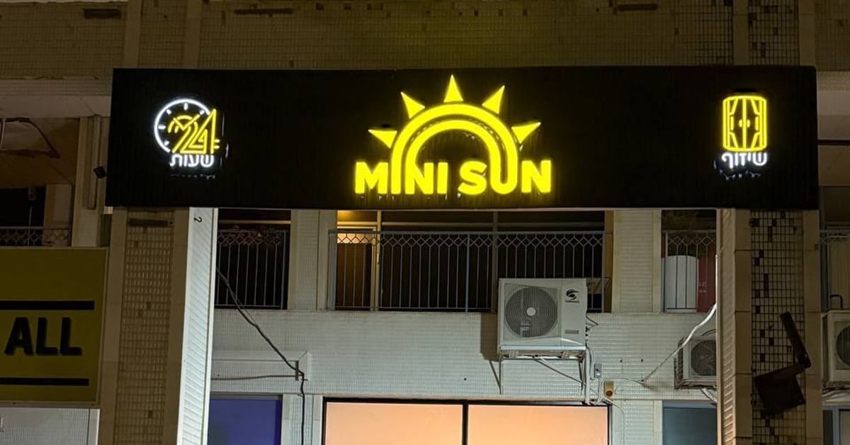 חזית הסניף בערב עם שלט MINI SUN מואר — מיני סאן אשקלון